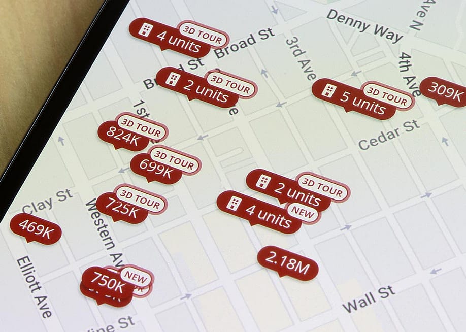 Homes listed for sale in Seattle, Washington, are seen on the map in the Zillow app on a smartphone. — Tada Images // Shutterstock