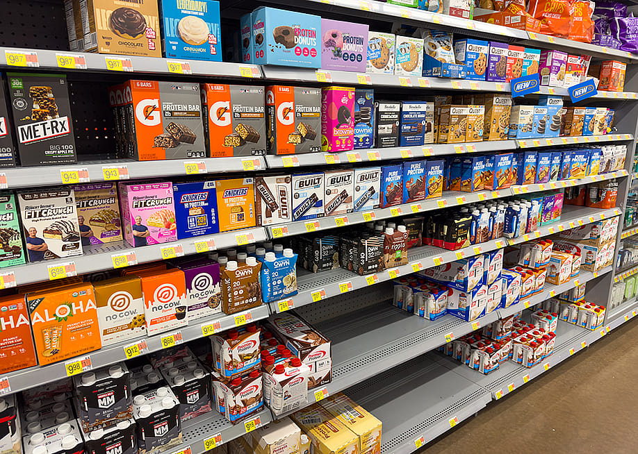 Shelves stocked with protein bars in a grocery store. — ZikG // Shutterstock