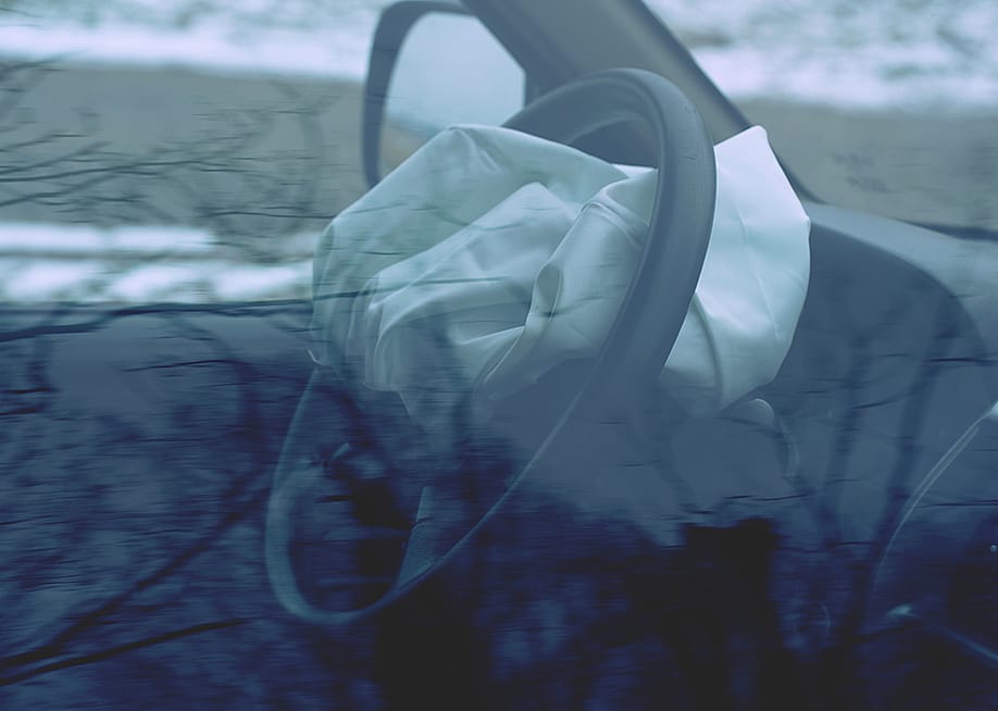 A car's steering wheel with a deployed airbag. — rdonar // Shutterstock