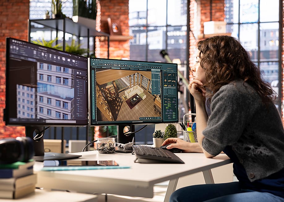 A professional interior designer using two monitors to work on a project. — DC Studio // Shutterstock