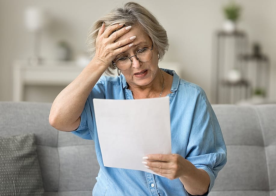 A frustrated senior woman reading a document at home. — fizkes // Shutterstock