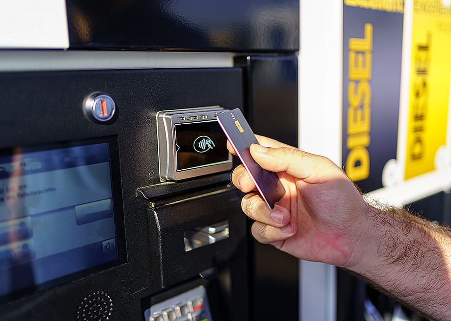 Hand of a person paying using card by the fuel pump at a gas station. — Jose Miguel Sanchez // Shutterstock