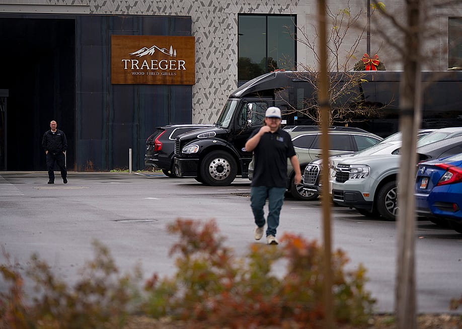 A person walking through the parking lot in the foreground with entrance to Traeger Grills Headquarters in behind, in Salt Lake City. — Bethany Baker // The Salt Lake Tribune