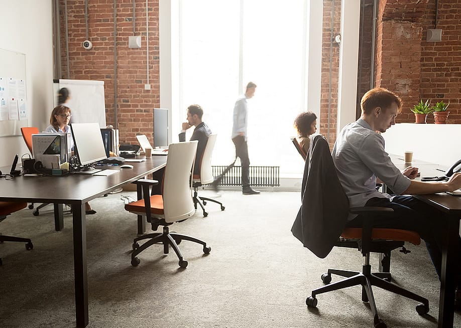 A busy team of employees around a modern office. — fizkes // Shutterstock