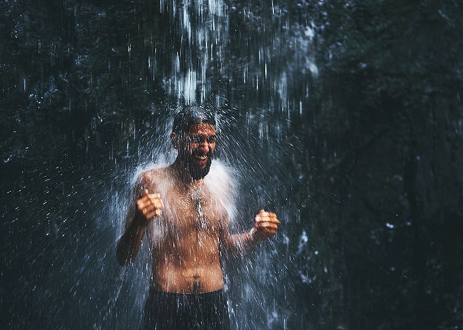 A man under a cold waterfall shower. — PeopleImages // Shutterstock