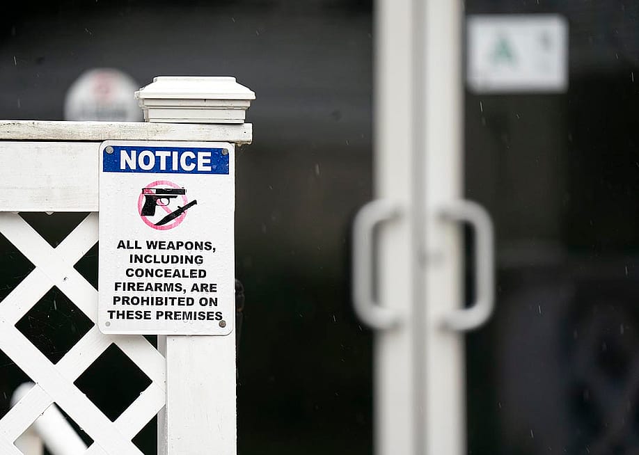 A sign prohibiting firearms at Willie's Bar & Grill posted on the fence outside in St. Helena Island, South Carolina. — Sean Rayford // Getty Images
