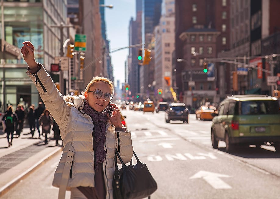 Woman signaling for a cab in New York City. — photoiva // Shutterstock