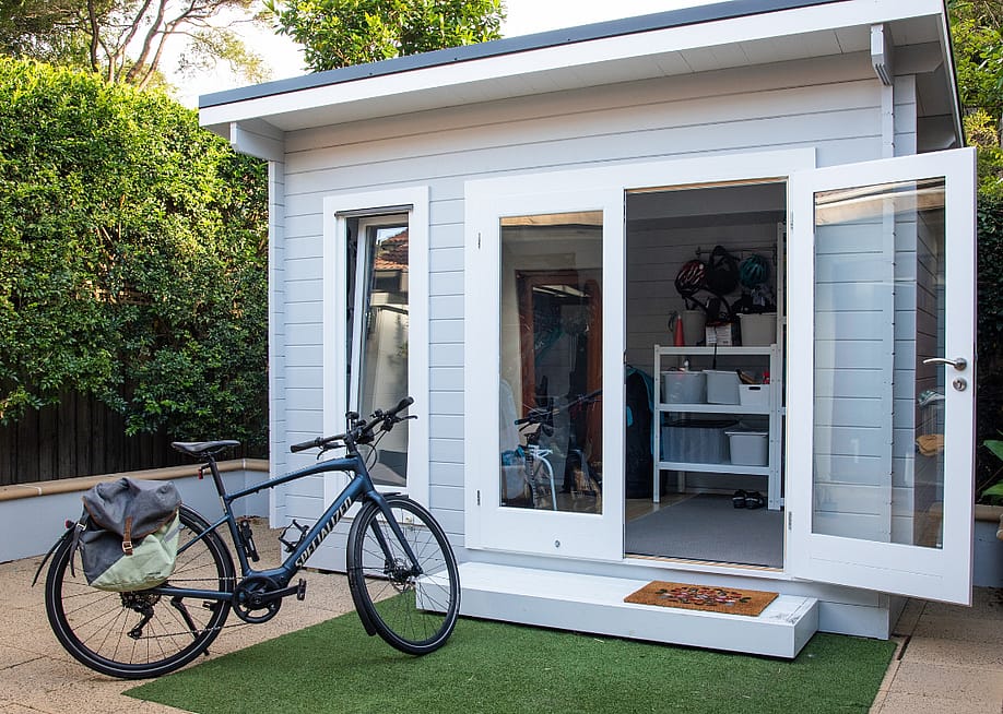 A nice shed with the doors open and a bike parked in front of it. — LIGHTITUP // Shutterstock