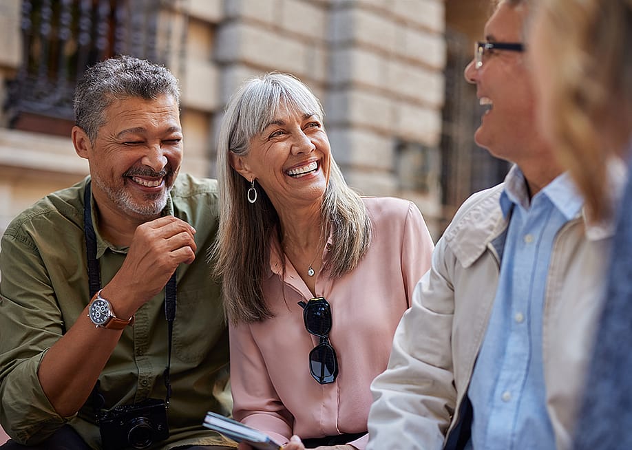 A group of senior friends laughing together on a day out. — Rido // Shutterstock