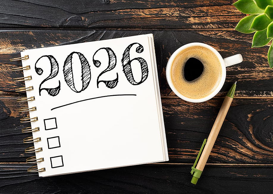 A notebook with a 2026 checkbox with a pen and a cup of coffee on a desk. — LanaSweet // Shutterstock