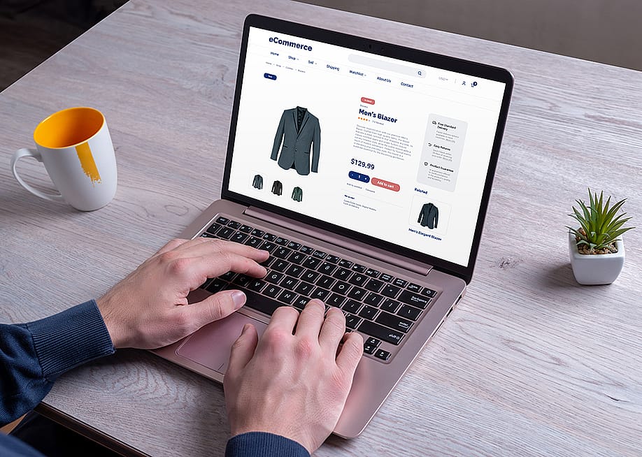 Person using a laptop to shop for men's blazer online. — RSplaneta // Shutterstock