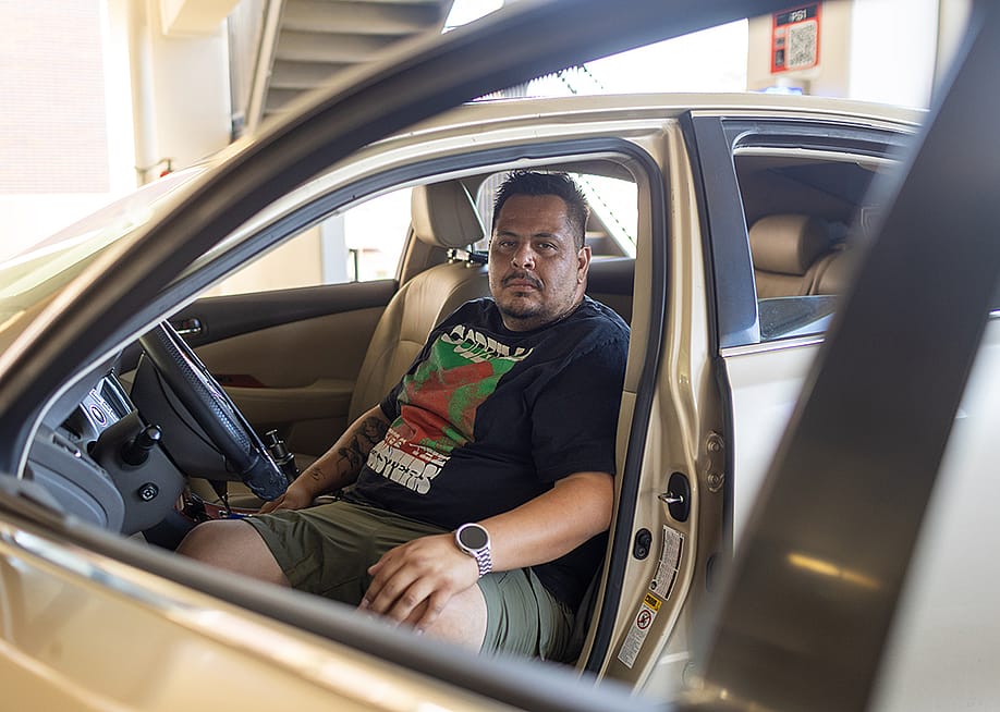 Edgar Rosales Jr. sits in the car where he lived for more than a year as a participant in the Safe Parking Program at Long Beach City College in Long Beach, Calif. There, he said, “you don’t have to be scared.” — James Bernal for The Hechinger Report