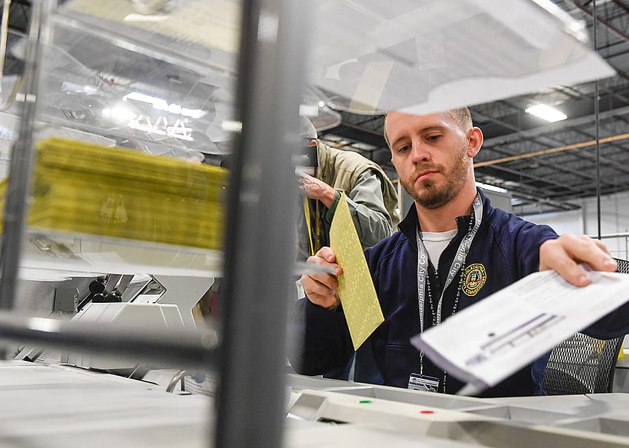 Poll workers demonstrate how ballots are received, processed, scanned, and securely stored on Election Day. — Matthew Hatcher // Getty Images
