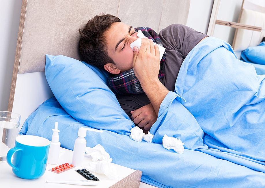 A sick man with flu lying in bed. — Elnur // Shutterstock