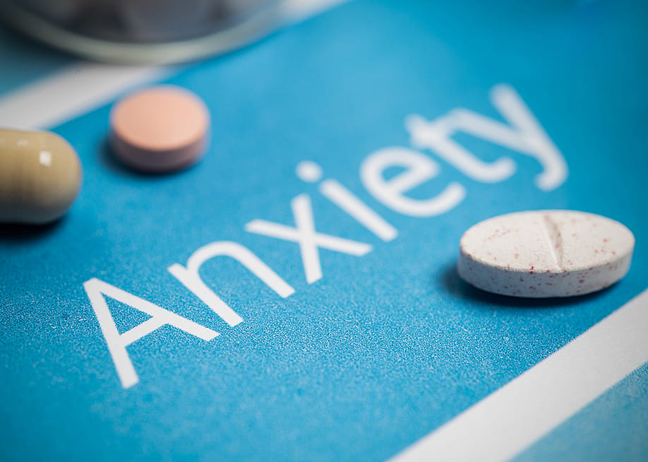 Medication and pills on top of a surface with the word 'anxiety'. — Minerva Studio // Shutterstock