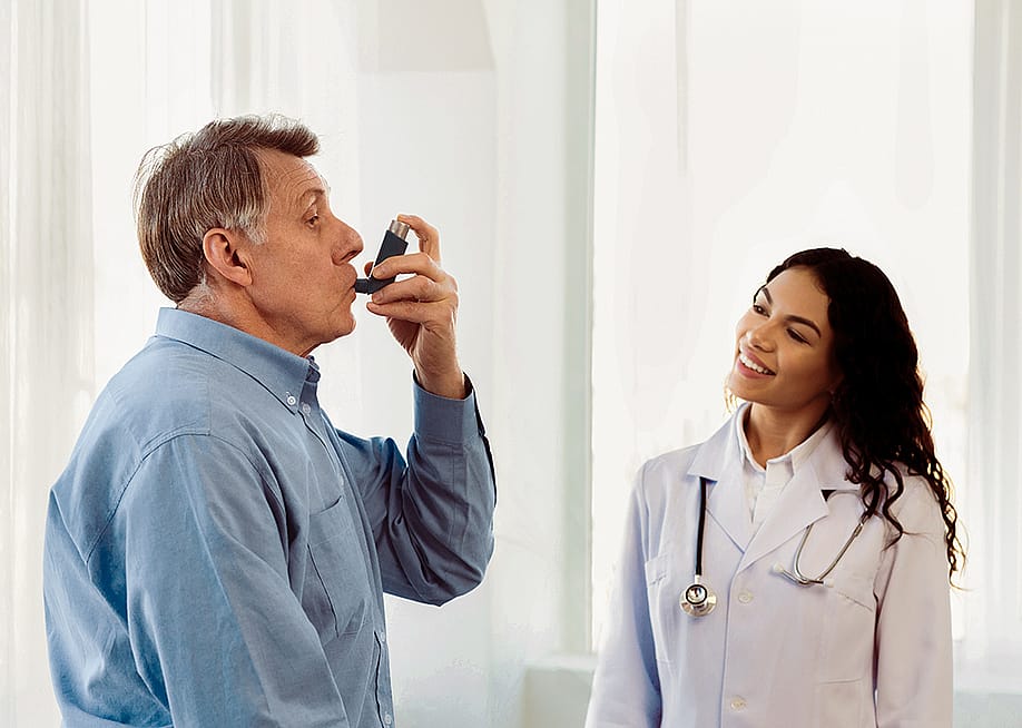 A female doctor monitoring her senior patient in taking an asthma inhaler. — Prostock-studio // Shutterstock