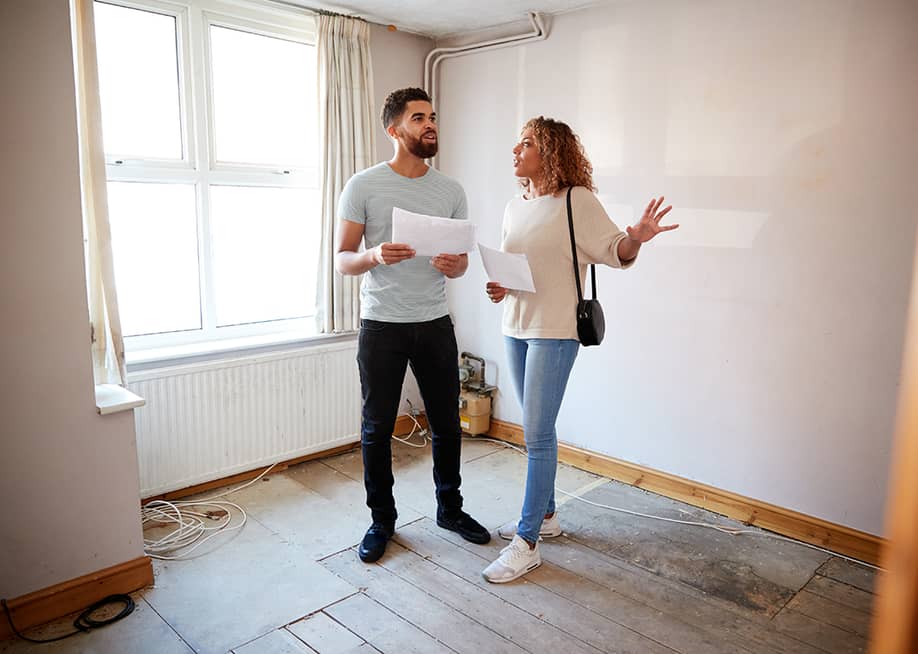 A couple surveys a house's area for renovation. — Monkey Business Images // Shutterstock
