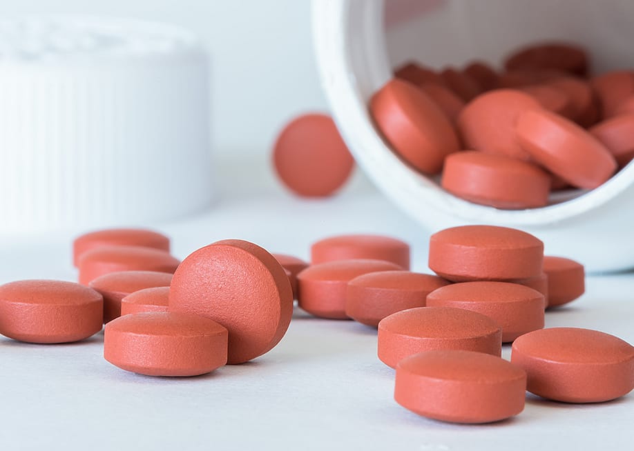 Ibuprofen tablets spilled from a bottle. — Michelle Lee Photography // Shutterstock