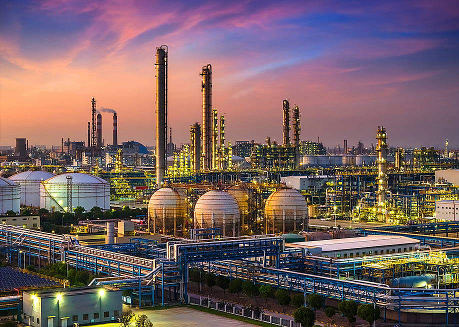 A view of a large industrial oil refinery and chemical plant during sunset. — ABCDstock // Shutterstock