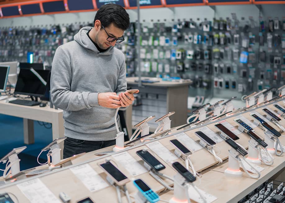 Man checking phone models at a store. — Kardasov Films // Shutterstock