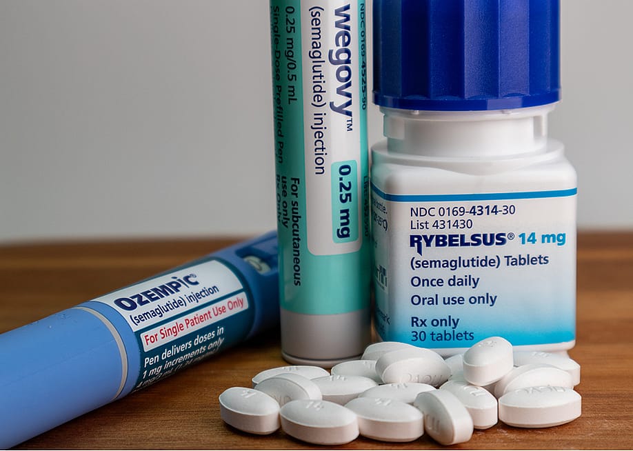 Ozempic, Wegovy, Rybelsus semaglutide medications on a table. — KK Stock // Shutterstock