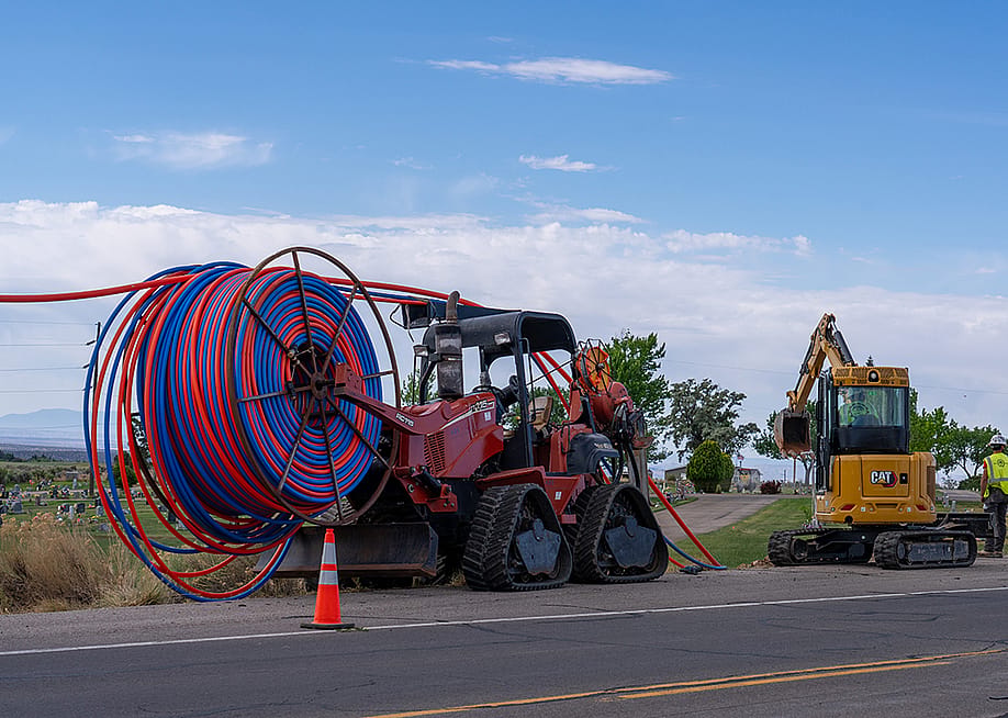 Machinery vehicles parked on roadside while installing internet fiber optic cables' plastic conduit underground in a rural area in Utah. — Jon G. Fuller // VW Pics / Universal Images Group via Getty Images