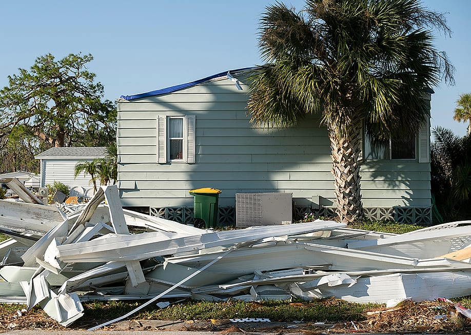 Debris on the side of a street after a hurricane in a residential area in Florida. — Bilanol // Shutterstock