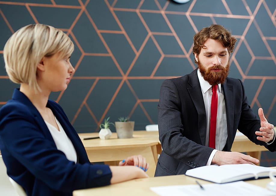 A female employee listening to her colleague at work. — Pressmaster // Shutterstock