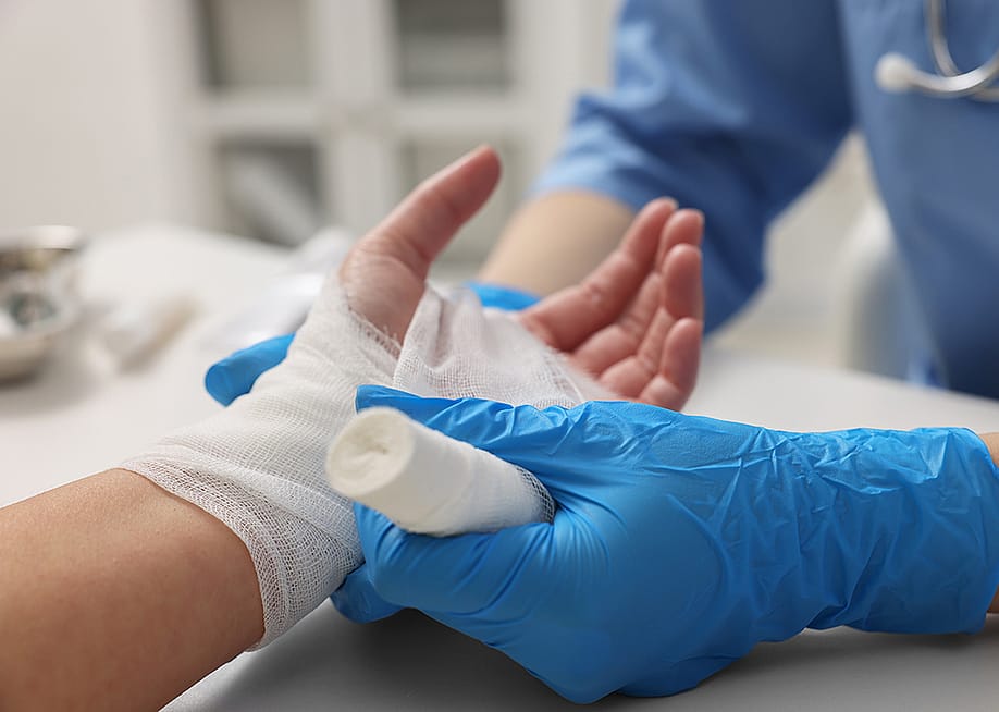 A doctor bandaging a patient's burned left hand. — New Africa // Shutterstock