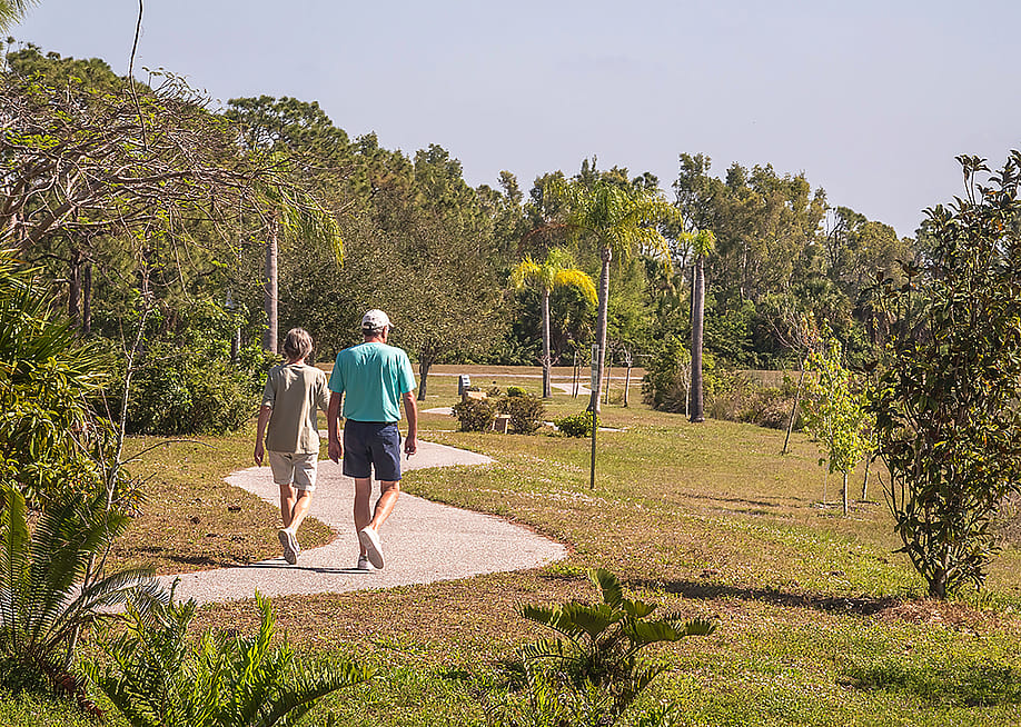 Two seniors walking a trail at a park during spring time. — Ken Schulze // Shutterstock