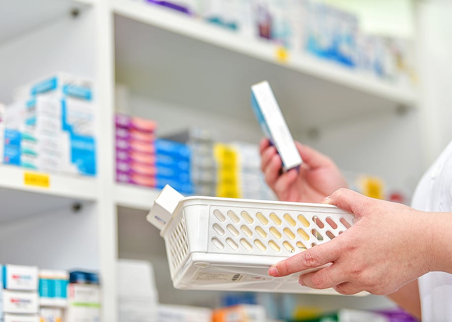 A pharmacist holding a basket to fill out a prescription. — i viewfinder // Shutterstock