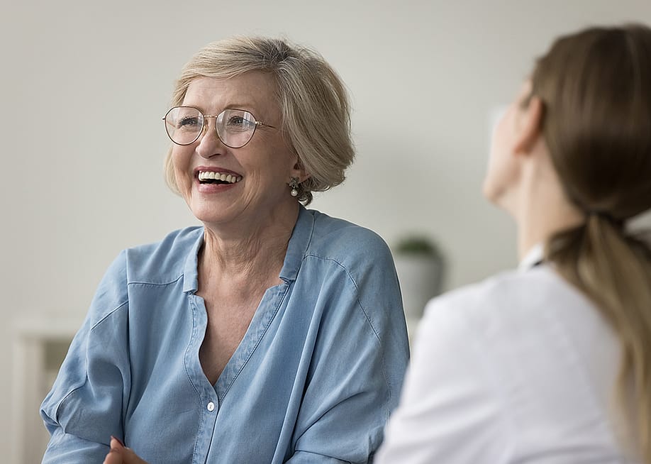 A senior woman laughing during clinic visit. — fizkes // Shutterstock