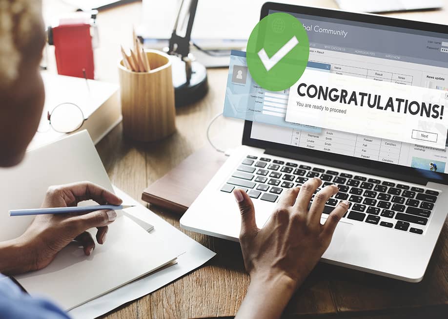 A female jobseeker opening an application with a 'congratulations' message using a laptop. — Rawpixel.com // Shutterstock
