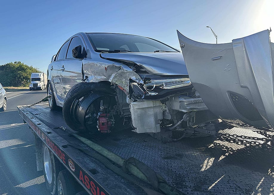 A crashed car loaded on a tow truck. — FlyingSauce // Shutterstock