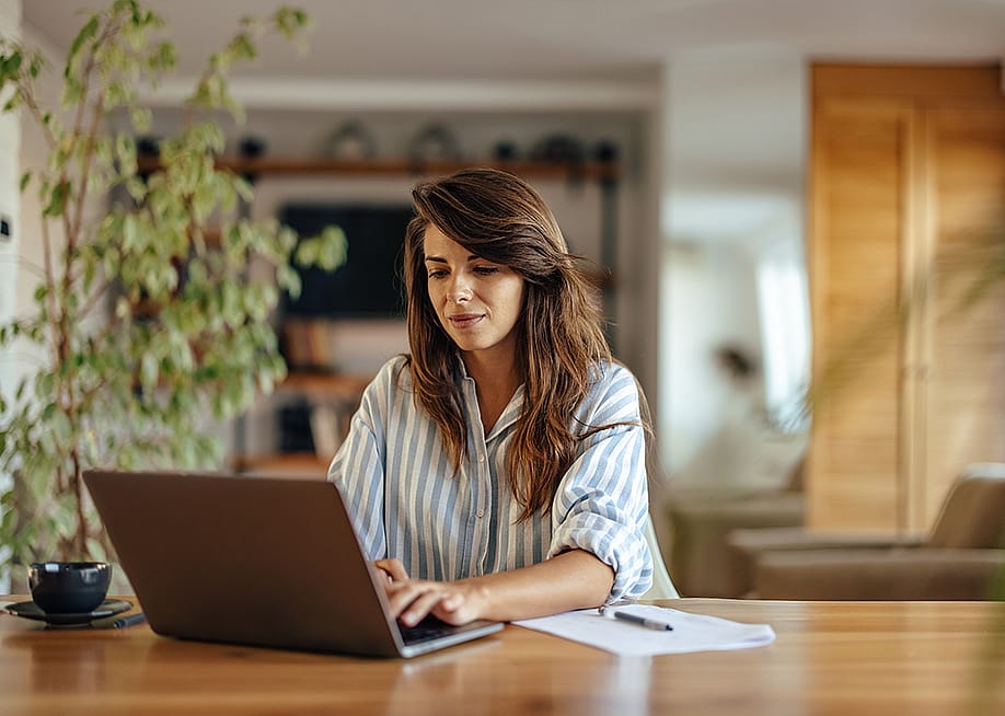 A woman using a laptop working from home. — Branislav Nenin // Shutterstock