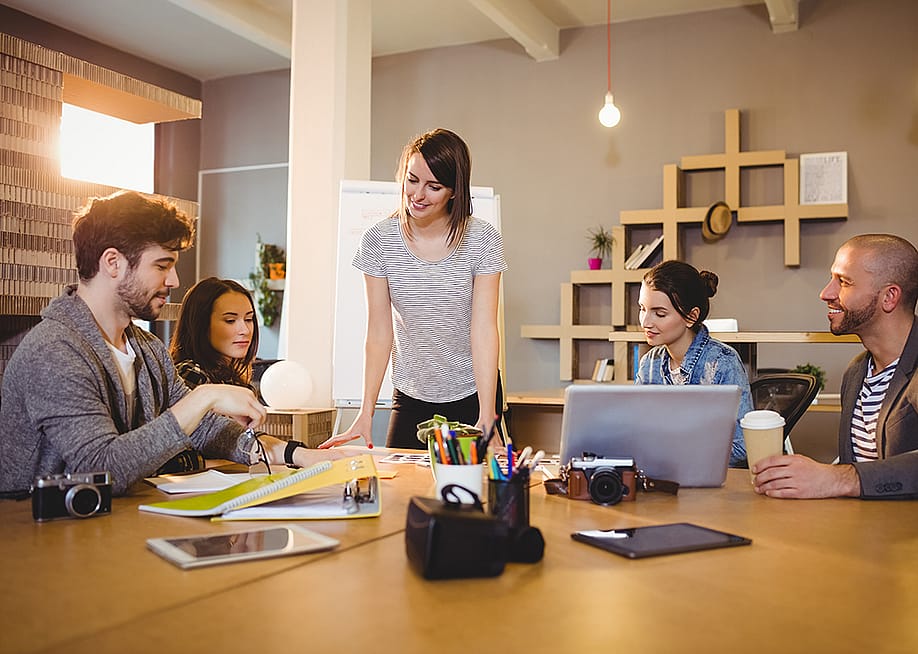 A graphic design team in a meeting room working on a project. — wavebreakmedia // Shutterstock