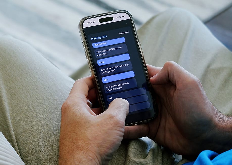 A man having a conversation with an AI therapy bot using a smartphone. — Matt Fowler KC // Shutterstock