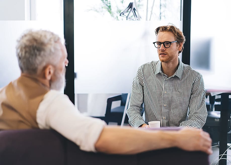 A young businessman listening to his senior manager. — GaudiLab // Shutterstock
