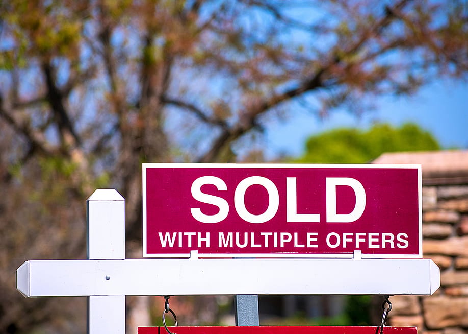 A 'sold with multiple offers' sign for a property. — Michael Vi // Shutterstock