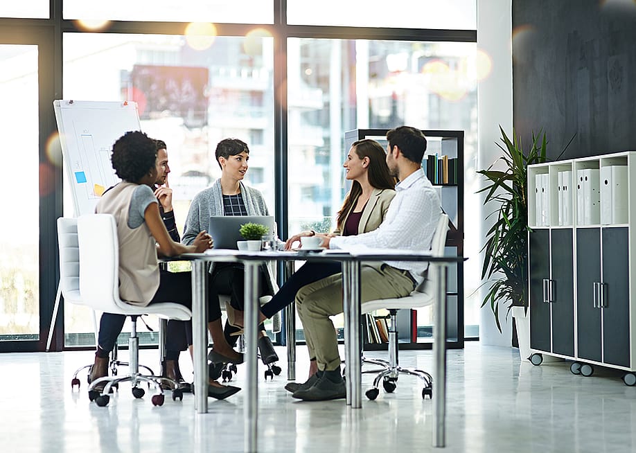 A group of businesspeople having a meeting together in a modern office — PeopleImages // Shutterstock