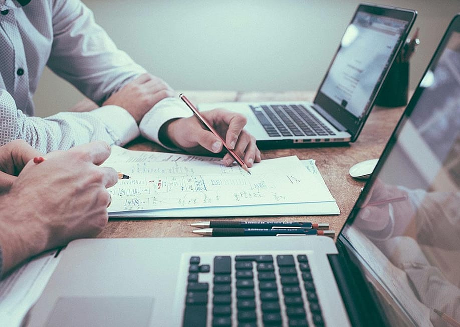 Businesspeople planning on paper in front of their laptop.s — NILAY PARUI // Shutterstock