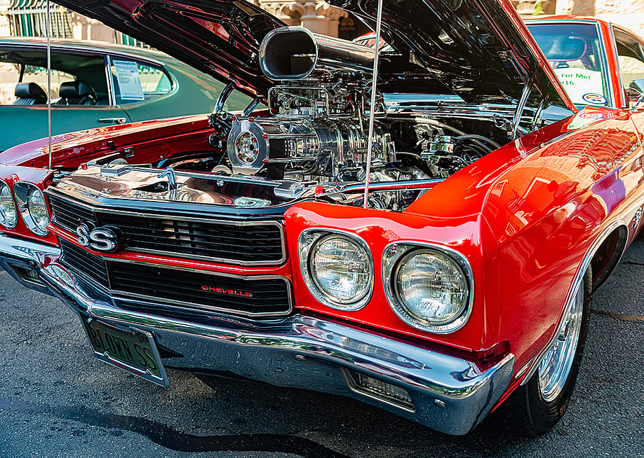 Opened hood of a red American Chevrolet Chevelle SS to show a custom engine. — Kosoff // Shutterstock