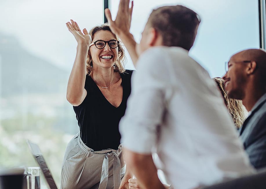 A businesswoman getting a high-five from a colleague. — Jacob Lund // Shutterstock