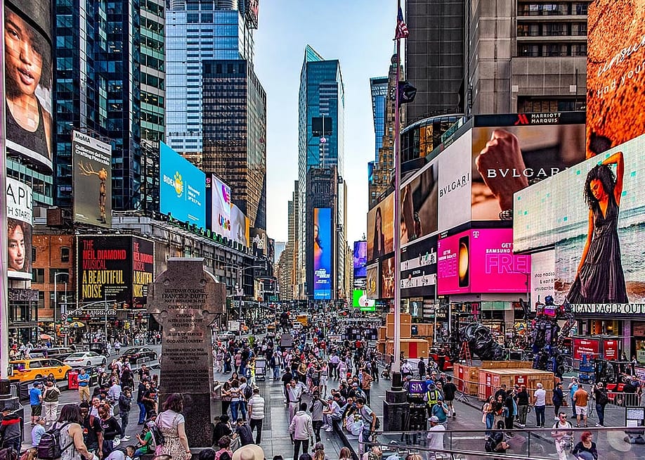 Crowds of people and lit up billboards around Times Square in New York City. — Domingo Saez // Shutterstock
