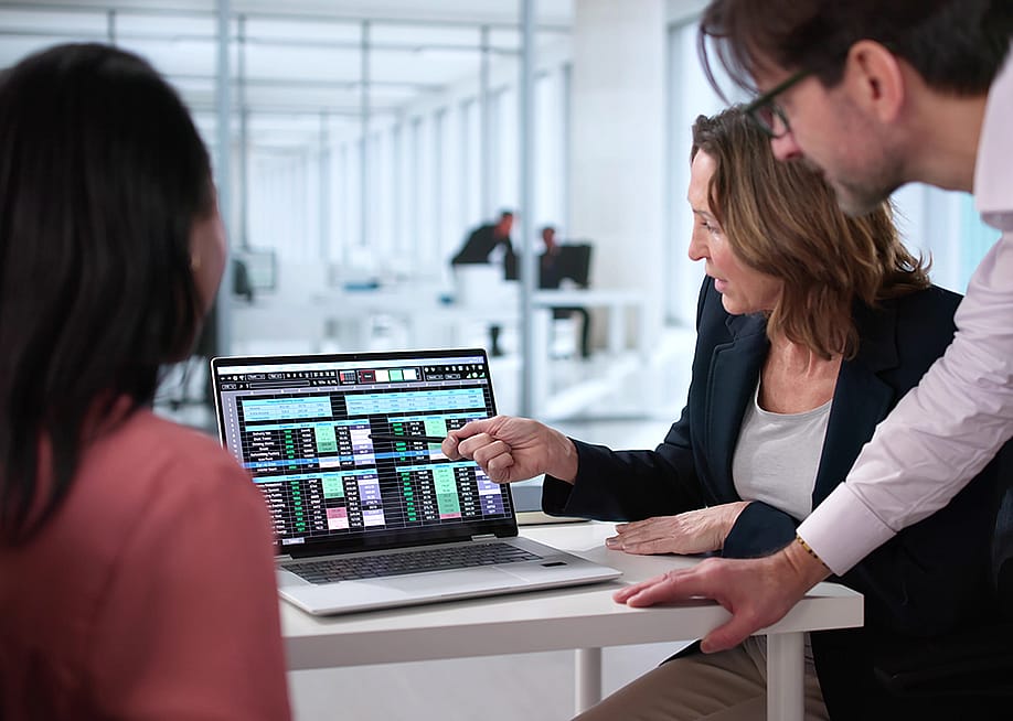 A business team reviewing billing reports displayed from a laptop. — Andrey_Popov // Shutterstock