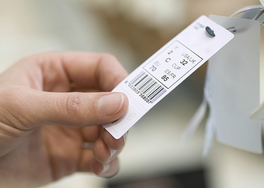 Close up on a woman's hand checking out a bra product tag. — sirtravelalot // Shutterstock