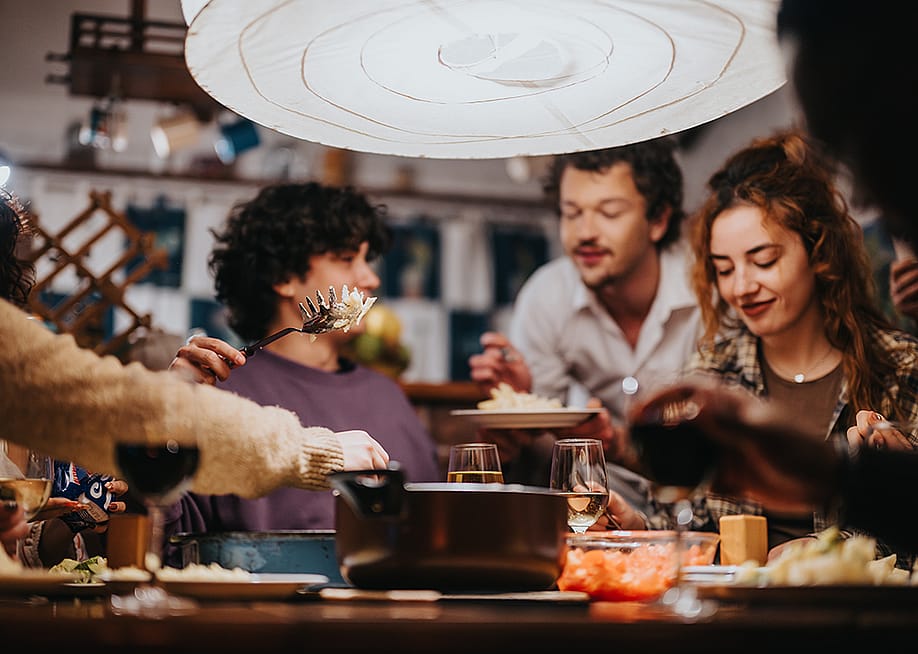 A group of friends having a dinner party. — Gorgev // Shutterstock