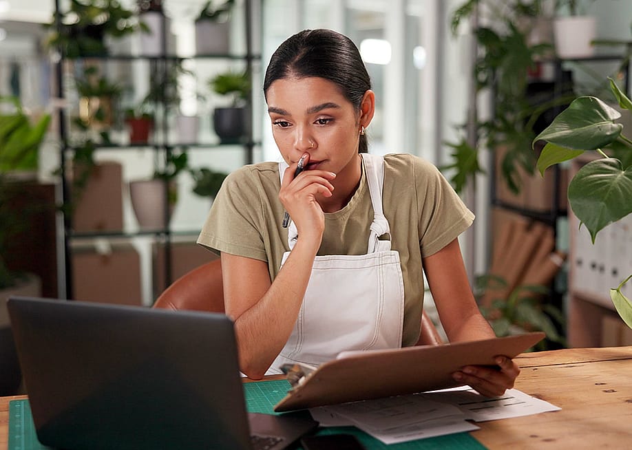 A female small flower business owner reviewing reports in the store. — PeopleImages // Shutterstock