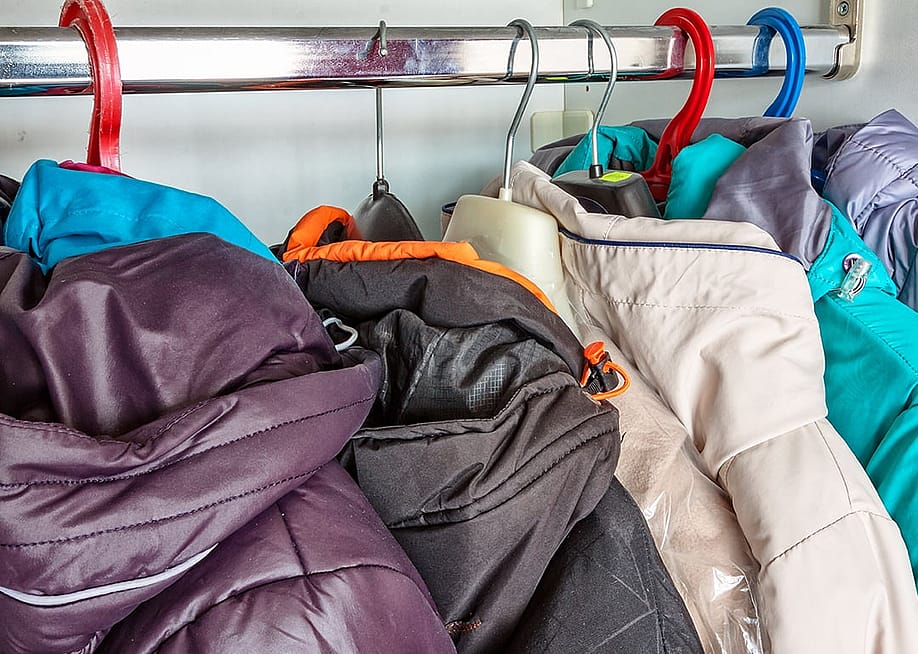 Winter jackets in a closet hanger. — ZAO2006 // Shutterstock