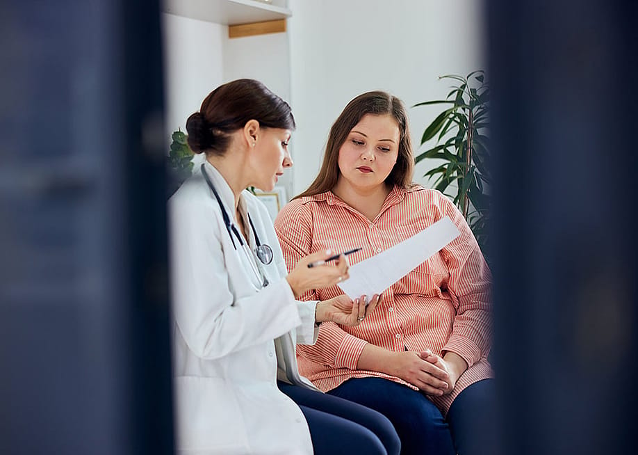 An plus-size young woman consulting with her doctor. — Branislav Nenin // Shutterstock